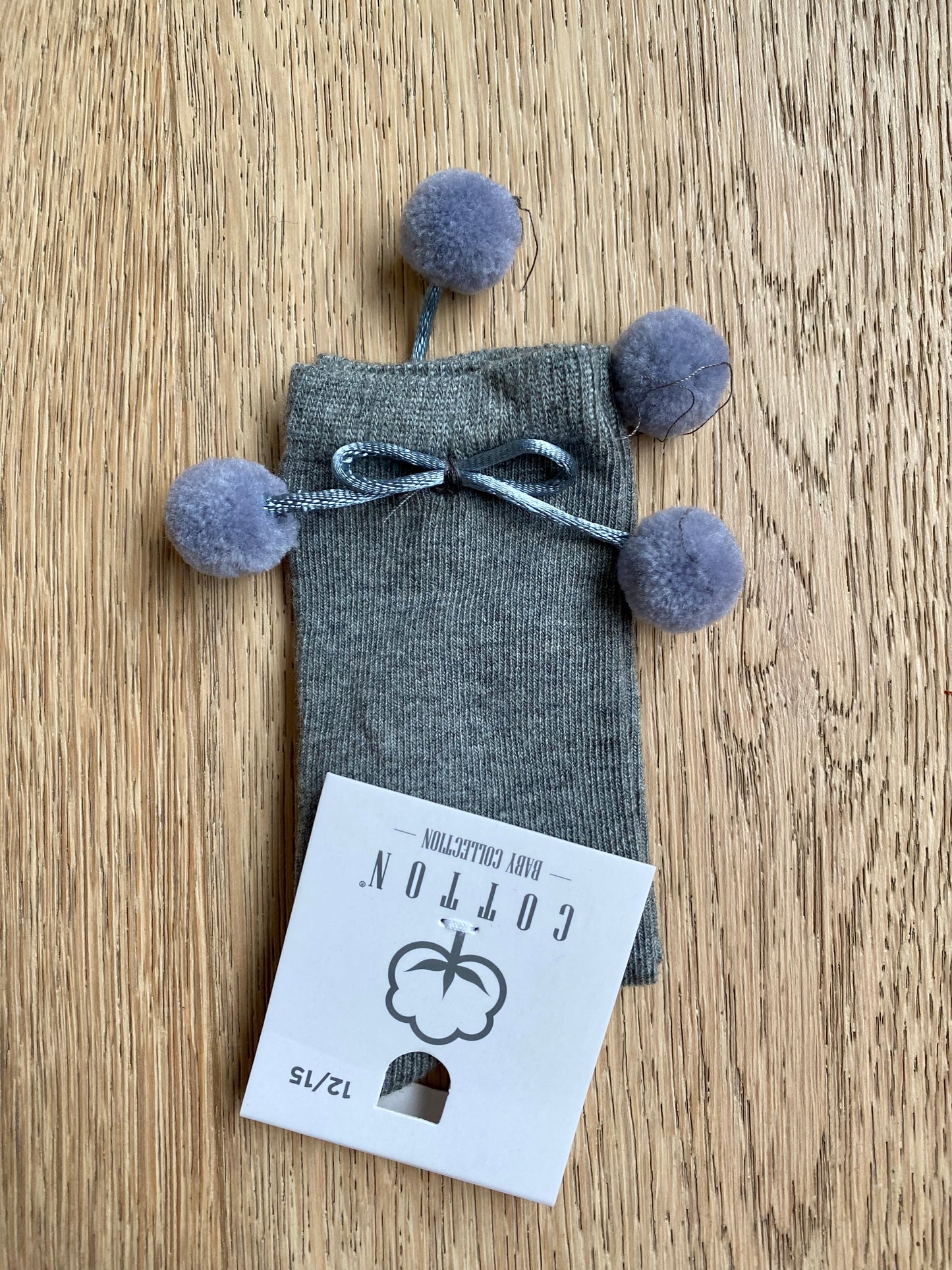 Grijze kniekous met pomponnetjes