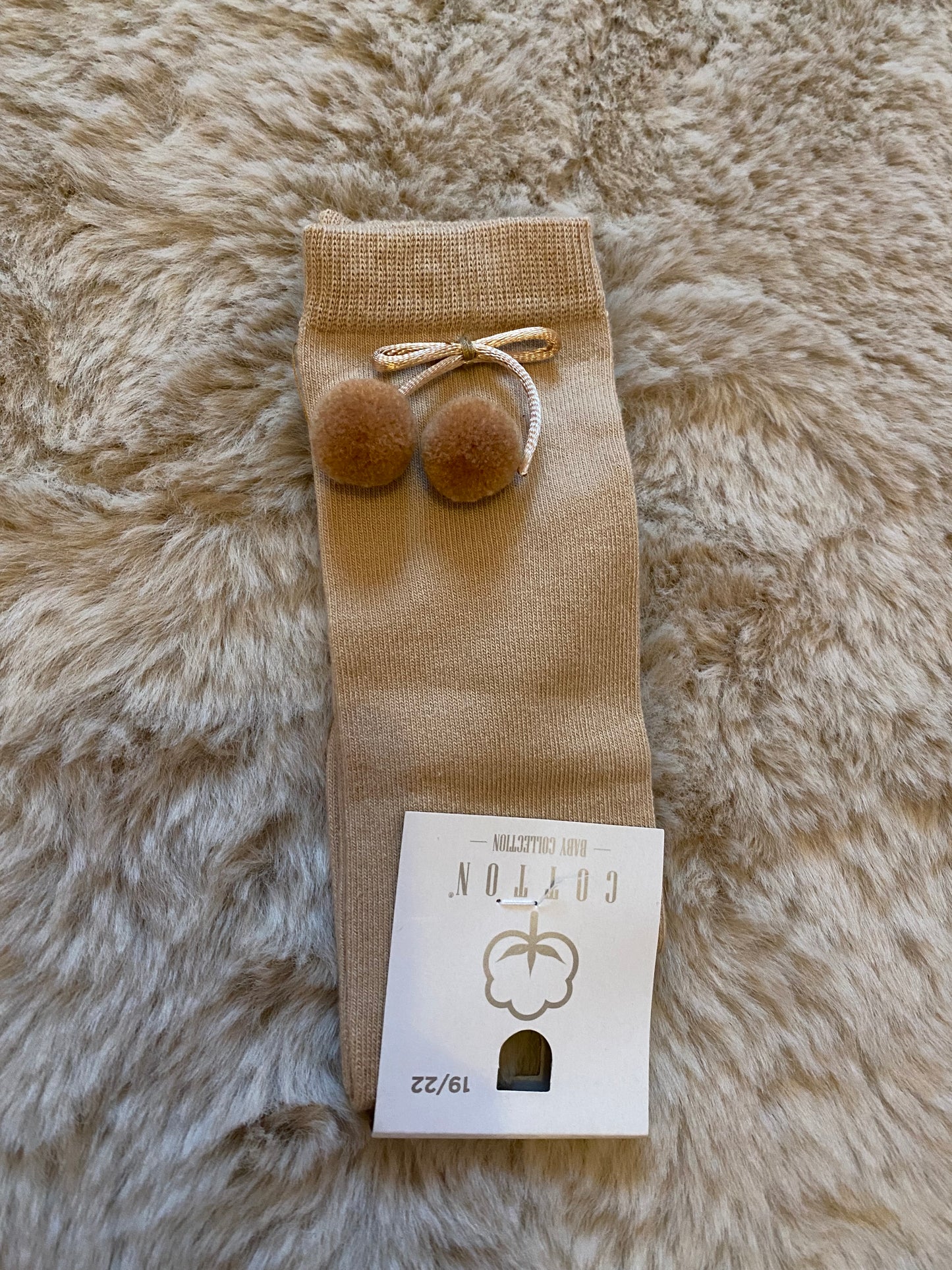 Beige kniekous met pomponnetjes