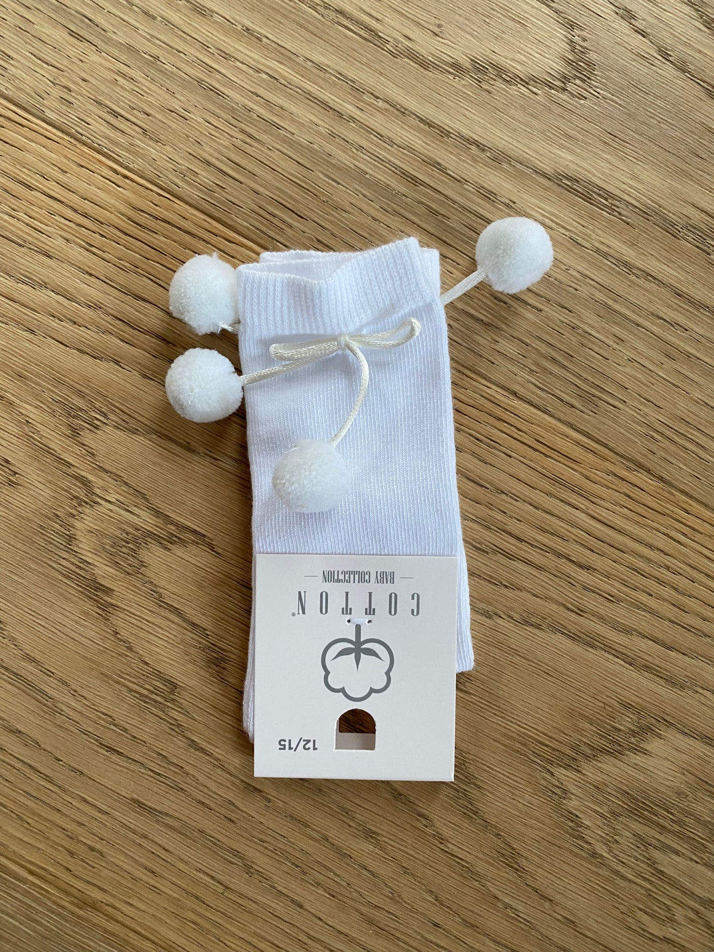 Witte kniekous met pomponnetjes