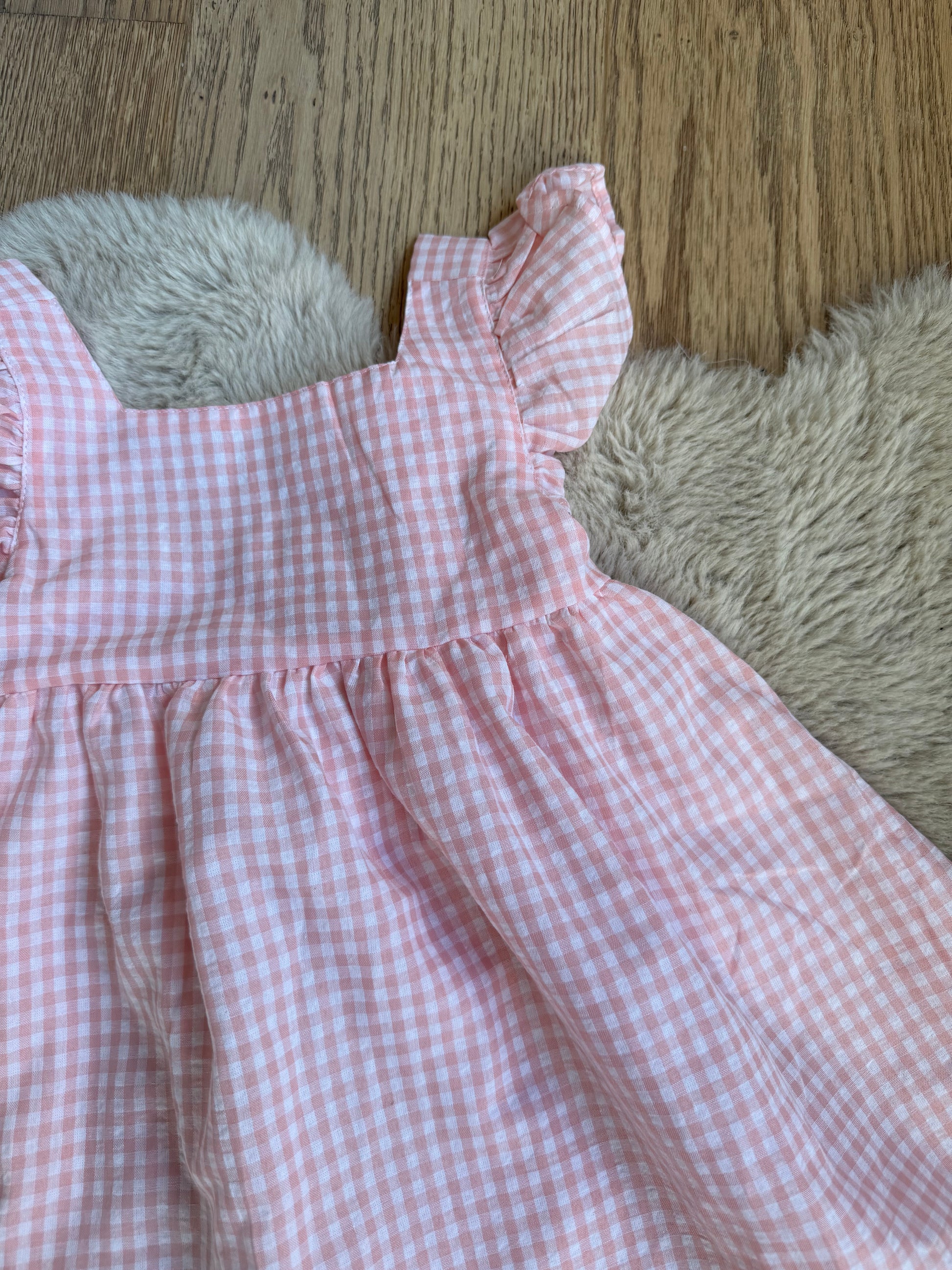 Roze feestjurk voor meisjes van Newness Kids met centrale strik en zachte plooien