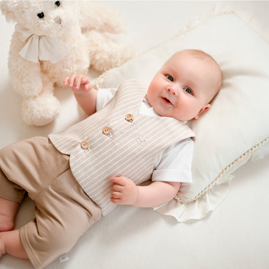 Baby jongen draagt beige driedelig kostuum tijdens feestelijke gelegenheid