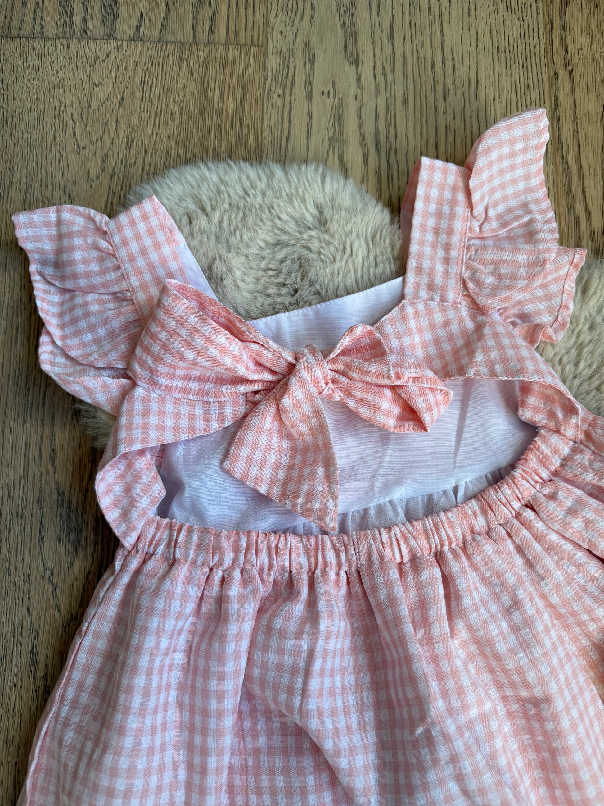 Elegante roze meisjesjurk, katoenmix, centrale strik en subtiele rokplooien.