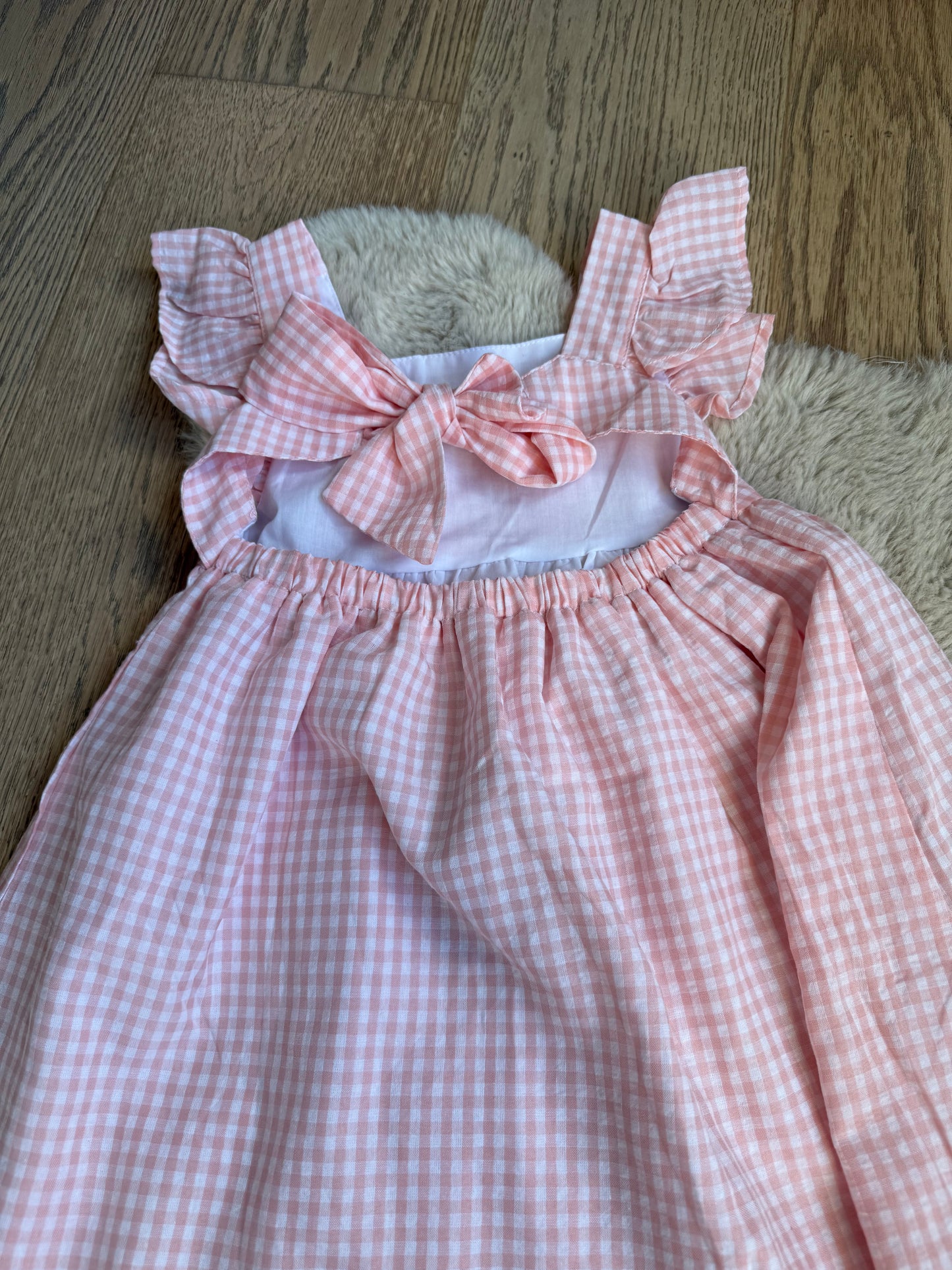 Elegante roze meisjesjurk, katoenmix, centrale strik en subtiele rokplooien.