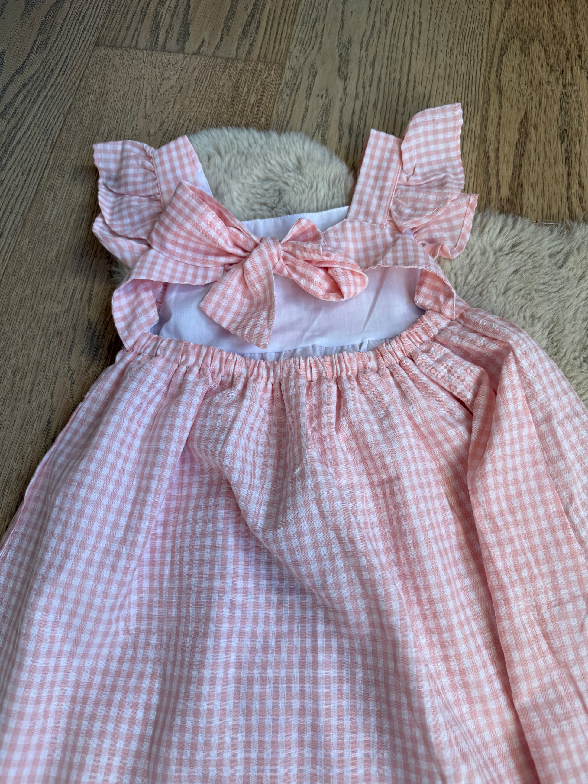 Elegante roze meisjesjurk, katoenmix, centrale strik en subtiele rokplooien.