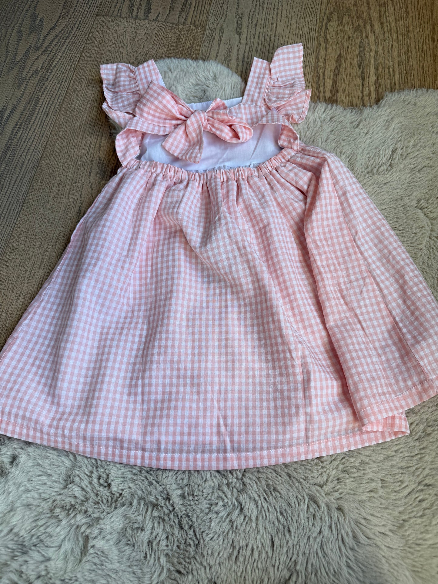 Elegante roze meisjesjurk, katoenmix, centrale strik en subtiele rokplooien.